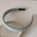 Gros plan d'un serre-tête en éponge vert clair avec étiquette Hand Made à l'intérieur - Serre-Tête 2CM / Vert Gris