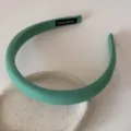 Gros plan d'un serre-tête rembourré vert menthe avec étiquette 'Hand Made' sur céramique. - Serre-Tête 2CM / Vert foncé