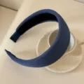 Close-up of navy blue ribbed fabric wide padded headband next to a white cup - 5cm Wide / Dark Blue