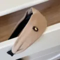 Détail d'un serre-tête large en daim camel avec un emblème de poney doré mignon - Kaki
