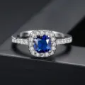 Elegante anillo de latón plateado con circón azul talla cojín y engaste tipo halo - Talla 9 / Piedra Azul