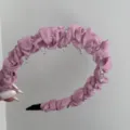 Close-up of elegant pink ruffled mesh headband with integrated clear plastic comb teeth - Mesh Wavy Headband / Pink