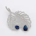 Elegant silver feather brooch with blue pear-cut stones and clear cubic zirconia stones - Blue Corundum