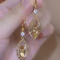 Close-up of elegant gold earrings with champagne marquise stones and sparkling crystals - Double Layer Leaf Marquise Rhinestone Style (E4453) / Light Burgundy Champagne