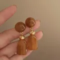 Elegant retro Maillard brown resin geometric drop earrings with gold-tone knot details - Woven Knot Geometric Style (E4051) / Light Burgundy Champagne