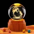 Vista dettagliata di una sfera di cristallo incisa in 3D con delfini su base in legno. - Dolphin Heart