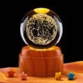 Detalle de bola de cristal de galaxia grabada en 3D con base de madera iluminada - Mapa estelar