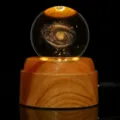 Vista detallada de una bola de cristal de galaxia grabada con láser 3D sobre base de madera. - Vía Láctea