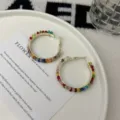 Detailed macro view of colorful crystal beaded gold hoop earrings on a decorative white plate - Colorful Crystal Hoop Style (E4893) / Gold
