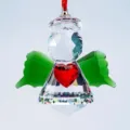 Detailed close-up of a faceted crystal angel pendant with red heart and green wings - Angel with Heart / Green Wings