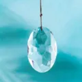 Detail view of an oval multi-faceted clear crystal suncatcher pendant for garden decoration - Transparent Style / With Lanyard