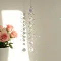 Detail shot of a spiral metal suncatcher with crystal beads creating colorful reflections - Colorful