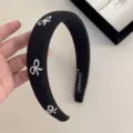 Elegante cerchietto imbottito nero con ricami di fiocchi bianchi per un look retrò - Cerchietto / Nero