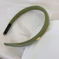 Élégant bandeau en satin rembourré vert olive avec un détail de logo en métal ovale doré - Vert
