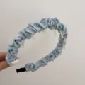Nahaufnahme eines hellblauen Satin-Haarreifs mit Rüschen und rutschfesten Zähnen. - Plissiertes Stirnband / Blau
