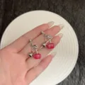 Detail shot of elegant French-style cherry earrings held in hand for scale - Round Cherry Style (E4812) / Silver Red