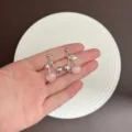 Elegant sweet pink cherry drop earrings with silver finish shown in hand display - Round Cherry Style (E4812) / Silver Light Pink