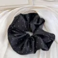 Vue détaillée d'un chouchou en satin noir avec un motif à pois blancs classique - Chouchou / Pois Noir