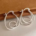 Dettaglio di orecchini a cerchio geometrici in argento con timbro S925 inciso a mano - Stile Avvolto Irregolare Geometrico (E4905) / Argento
