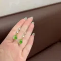 Elegantes pendientes de tulipán dorados con ojo de gato verde y strass - Dorado