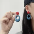 Red and blue geometric hoop earrings worn by model in a stylish summer look - Minimalist Contrast (Red) / Red