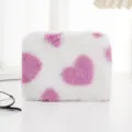 Nahaufnahme einer weichen, weißen Plüschtasche mit einem süßen rosa Herzmuster-Design - Rosa Weiß