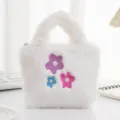 Primo piano di borsa bianca di peluche con motivi floreali ricamati colorati e texture morbida. - Bianco Fiore