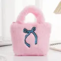 Detail van de zachte roze pluche mini handtas met een blauw geborduurde strik erop - Strik Roze