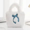 Gedetailleerd overzicht van een zachte witte pluchen tas met blauwe strik. - Strik Wit