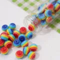 Rainbow striped resin beads for DIY jewelry making, pouring from a clear glass bottle. - Striped Round Beads 10mm Hole 1mm Blue Series 25 Pcs/Pack