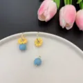 Detailed shot of asymmetric yellow daisy earrings with blue beads in French pastoral style - Asymmetric Style (E1577 Gold)
