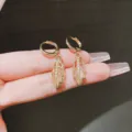 Vista dettagliata di eleganti orecchini a foglia d'oro con strass e pietra occhio di gatto - Stile Clip Orecchio Foglia Svuotata (E1698) / Oro