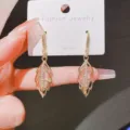 Dettaglio di orecchini a foglia con pietra occhio di gatto e strass luccicanti - Stile Gancio Orecchio Foglia Svuotata (E1698) / Oro