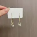 Dettaglio di eleganti orecchini floreali dorati con zirconi e perle bianche. - Stile Perla Fiore a Goccia (E1700) / Oro
