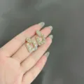 Dettaglio di orecchini geometrici quadrati con pavé di strass brillanti e lucenti. - Stile Quadrato Geometrico Pavè (E1741) / Oro