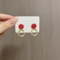 Primo piano di orecchini pendenti geometrici rossi e oro su scheda display - Stile Geometrico Anello Rosso Vintage (E1762) / Rosso oro
