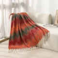 Close-up of ethnic jacquard pattern and tassel fringes on orange mohair-like throw blanket - Great Wall Orange Red