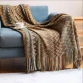 Primer plano de manta de punto bohemia con diseño en zigzag y flecos - 127x180cm / Amarillo