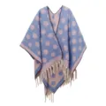 Detailansicht eines dicken Mohair-Ponchos mit Punkten und weichen dekorativen Quasten - Blau und Violett