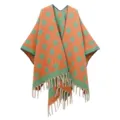 Detailansicht eines orange-grünen Jacquard-Ponchos mit Polka Dots und Fransen - Orangegrün