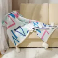 Bohemian knitted throw blanket with colorful geometric patterns and white tassels on a sofa - Geometric Blue Pink
