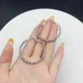 Textured silver-colored large hoop earrings displayed on hand for size and style - Textured Geometric Hoop (E2730) / 4cm / Silver