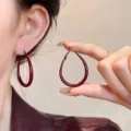 Minimalist wine red teardrop hoop earrings for women shown being held by fingers - Small (E4219) / 4.8cm/3.3cm / Burgundy