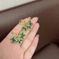 Exquisite gold-plated leaf earrings featuring vibrant emerald green crystal inlays for women - Green Triple Leaf Clip-on (E2607)
