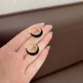 Detail showing vintage U-shaped hoop earrings with black enamel and gold-plated finish - U-Shaped Ear Buckle / Gold Black