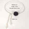 Detail view of pearl waist chain with black camellia flower and size measurements - Camellia Pattern / Black