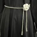 Close-up detail of an elegant white camellia pearl waist chain accessory for dresses. - Camellia Pattern / White