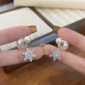 Macro shot of elegant snowflake earrings featuring sparkling rhinestones and twin pearls - Snowflake Pearl Style (E4548) / Silver