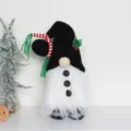 Nahaufnahme einer handgefertigten Weihnachtszwerg-Puppe mit schwarzen Mäuseohren - Schneemann
