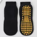 Professional black non-slip trampoline yoga socks featuring durable yellow grips - Black